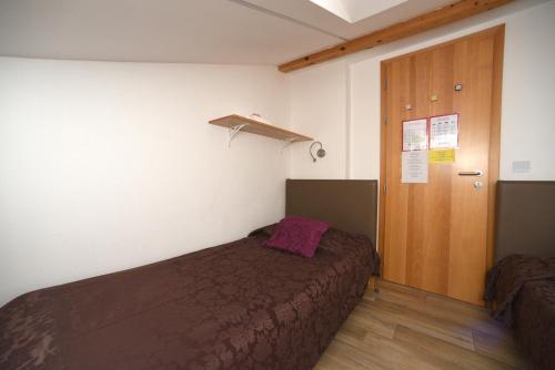 a bedroom with a bed with a purple pillow on it at Fedrig Hostel rooms Apartment for 10 in Kobarid