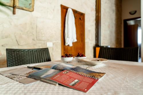 una mesa con un libro encima de una mesa en Ilice Country House, en Marina di Ragusa