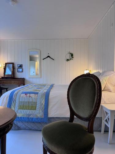 a bedroom with a bed with a chair and a table at Egn Boutique Hotel in Stege