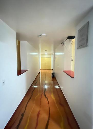 an empty room with a wooden floor and white walls at Hotel Mónaco de Fusa in Fusagasuga