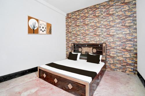 a bedroom with a bed and a brick wall at Hotel O VK Hotel And restaurant in Prayagraj