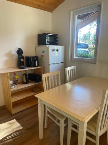 eine Küche mit Tisch und Stühlen und einem Kühlschrank in der Unterkunft Chez Marielle in Parentis-en-Born