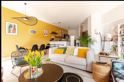 - un salon avec un canapé blanc et un mur jaune dans l'établissement La maison de FREDE, à Pézenas