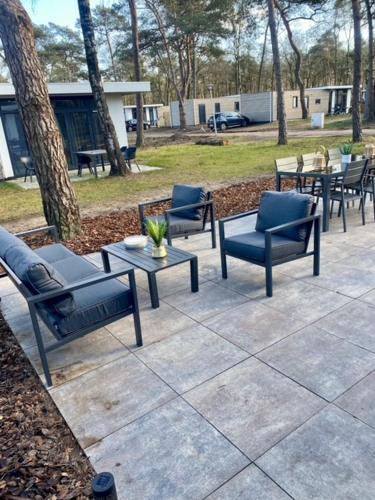 a group of chairs and tables on a patio at Natuurhuisje Hellendoorn met luxe Hottub in Haarle