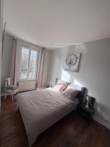 a bedroom with a bed and a clock on the wall at Super appartement proche Disney in Quincy-Voisins