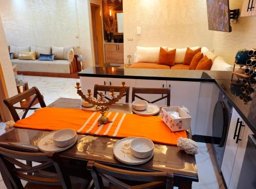 a dining room with a table and a living room at Azur appartement essaouira in Essaouira