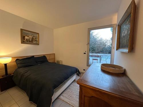 une chambre avec un lit, une table et une fenêtre dans l'établissement Maison aix en Provence piscine, à Aix-en-Provence