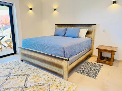 a bedroom with a bed with a blue comforter and a table at Los Cerritos Oceanview at The Point,8 in San Carlos
