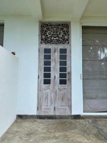 a wooden door on a white house at Villa LA Kurumba in Ambalangoda