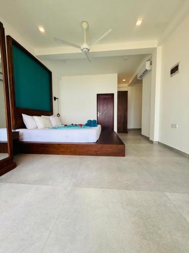 a bedroom with a large bed with a green screen at Villa LA Kurumba in Ambalangoda