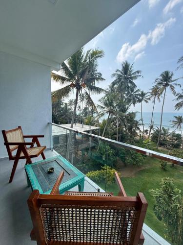 a balcony with a table and a view of the ocean at Villa LA Kurumba in Ambalangoda