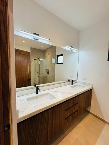 a bathroom with a sink and a large mirror at Los Cerritos Oceanview at The Point,8 in San Carlos