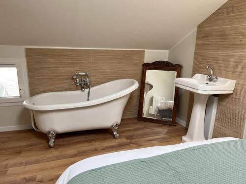 a bathroom with a bath tub and a sink at Gîte de la Sablonnière in Haut-Orbé