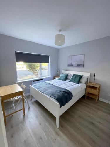 a bedroom with a large bed and a window at Luxury By The Coast- sleeps 4 in Galway