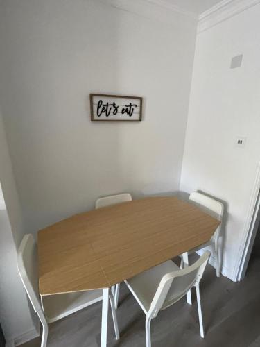 a dining room table with chairs and a sign on the wall at Luxury By The Coast- sleeps 4 in Galway