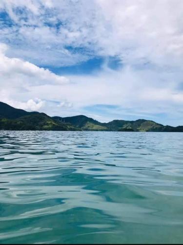 a large body of water with mountains in the background at Chalé Recanto da Cachoeira in Paraty