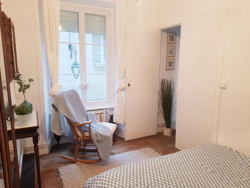 - une chambre avec une chaise et une fenêtre dans l'établissement Saint Malo Intra-muros Appart T2, all on foot!, à Saint-Malo