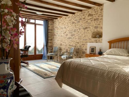 une chambre avec un lit, une table et des chaises dans l'établissement La Grange, à Naillat