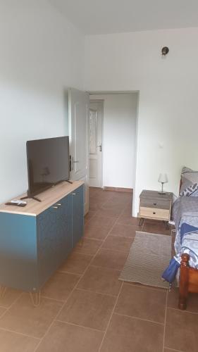 a living room with a flat screen tv and a bed at Le Rahma in Sada