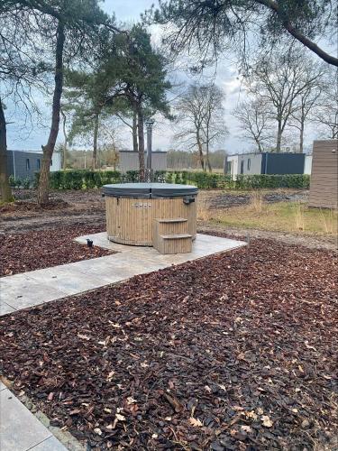 a trash can sitting on a sidewalk in a park at Natuurhuisje Hellendoorn met luxe Hottub in Haarle