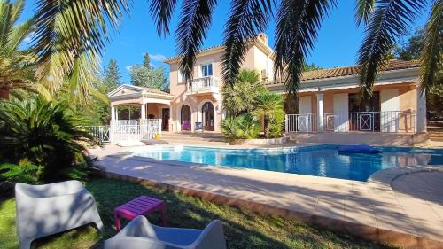 une maison avec une piscine devant une maison dans l'établissement Villa- Saint-Raphaël, à Saint-Raphaël
