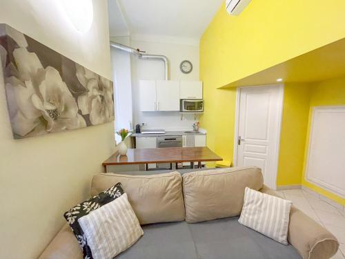 un salon avec un canapé et une cuisine dans l'établissement Charmant appartement atypique au coeur du Vieux-Nice, à Nice