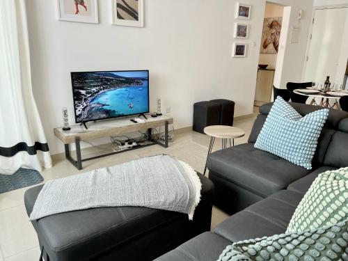 a living room with two couches and a flat screen tv at STAY Chromata Lagoon Apartment in Protaras