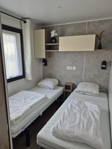 une chambre avec deux lits et une fenêtre dans l'établissement Le Domaine de Litteau 4 étoiles emplacement 404, à Litteau