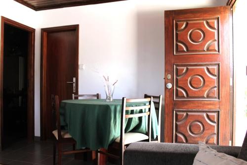a dining room with a table and a wooden door at Miguas House in Baião