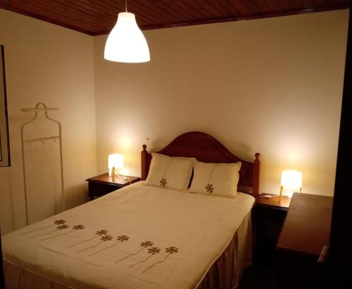 una camera da letto con un letto con due comodini e due lampade di Miguas House a Baião