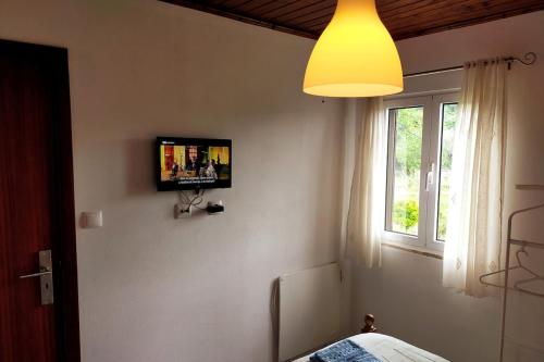 a bedroom with a tv on the wall and a window at Miguas House in Baião