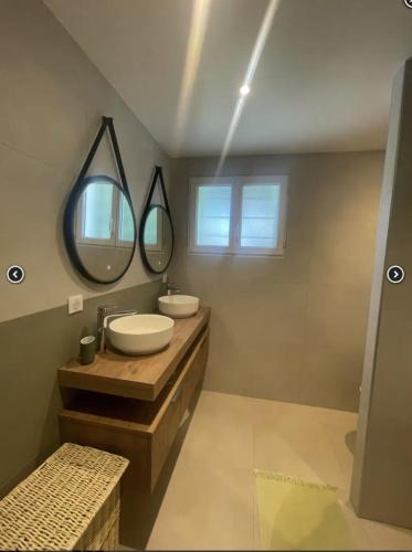 une salle de bain avec deux lavabos et un grand miroir dans l'établissement Saladjo, au Bois-Plage-en-Ré