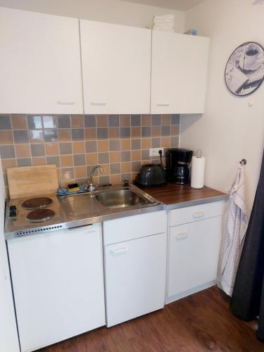 una cucina con mobili bianchi e un lavandino di Zentrale Ferienwohnung in Bergen auf Rügen a Bergen auf Rügen