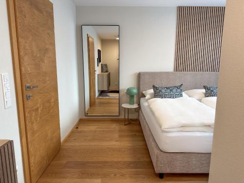 ゼーキルヒェン・アム・ヴァラーゼーにある"ONE" - Premium Apartments Seekirchen - Dein Rückzugsort mit exklusivem Flair und privater Terrasseのソファと鏡のあるリビングルーム