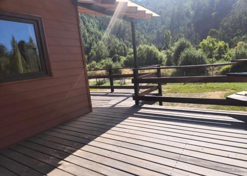 eine Holzterrasse mit einer Bank auf einem Haus in der Unterkunft Casona octava región in Concepción