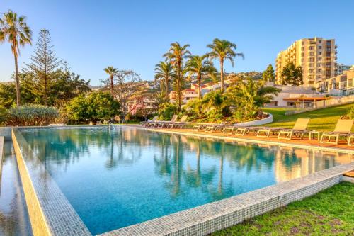 a swimming pool in a resort with palm trees at Funchal Acqua Blue 8E, a Home in Madeira in Funchal