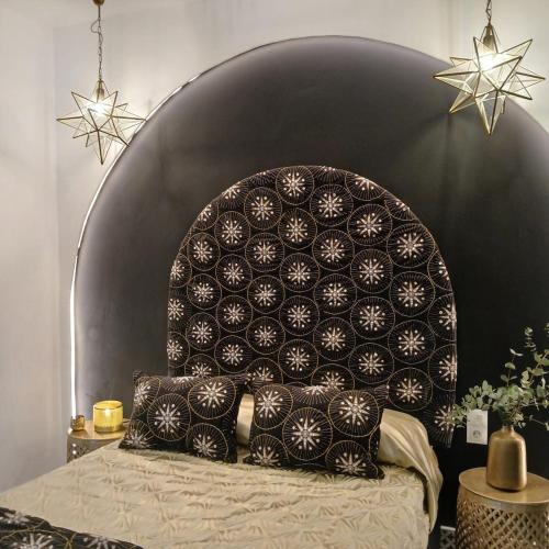 a bed with a black and white headboard with pillows at Beautiful penthouse with terrace next to the Cathedral in Cádiz