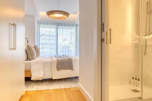 a bedroom with a bed and a glass shower at Funchal Acqua Blue 8E, a Home in Madeira in Funchal