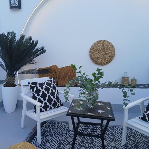 a living room with two chairs and a table at Beautiful penthouse with terrace next to the Cathedral in Cádiz