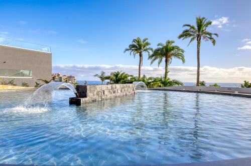 a pool with two water fountains in a resort at Funchal Acqua Blue 8E, a Home in Madeira in Funchal