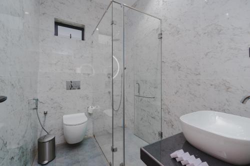 a bathroom with a shower and a toilet and a sink at Orbit88 Hotel by AMR in Kandy