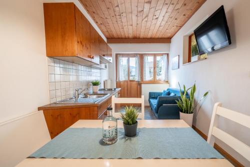 Una cocina con una mesa y una sala de estar. en Apartments Palma, en Cortaccia