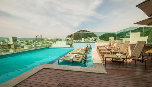 a swimming pool with tables and chairs on a building at Am&eacute;ricas Copacabana Hotel in Rio de Janeiro