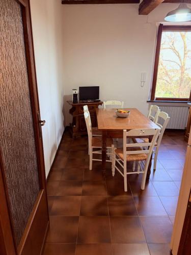 a dining room with a table and chairs and a desk at Ciliegia di Lari - Attico in Lari