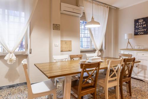 a dining room with a wooden table and chairs at L'Erika in Città in Livorno