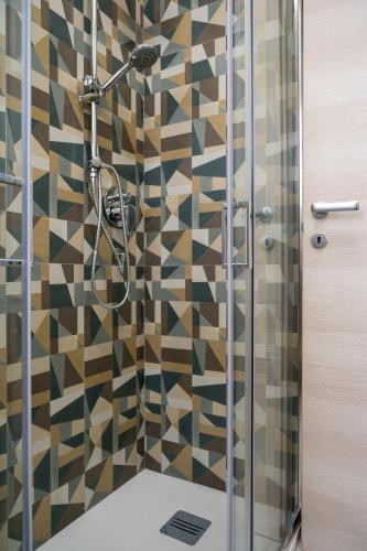 a shower in a bathroom with a mosaic tile wall at L'Erika in Città in Livorno