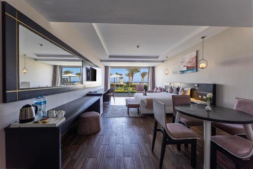 a hotel room with a bed and a dining room at Sataya Resort Marsa Alam in Marsa Alam City