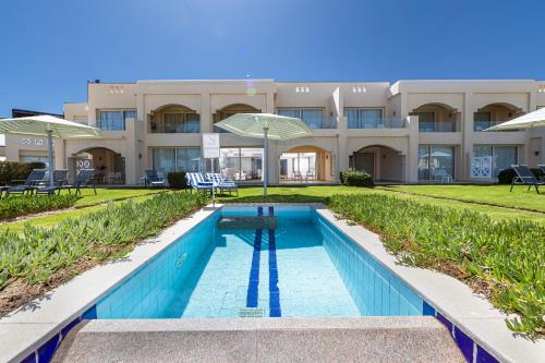 a swimming pool in front of a building at Sataya Resort Marsa Alam in Marsa Alam City