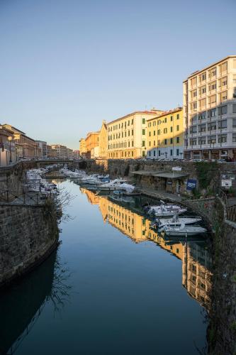 a group of boats in a river with buildings at L'Erika in Città in Livorno