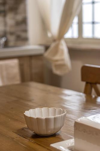a white bowl sitting on top of a wooden table at L'Erika in Città in Livorno